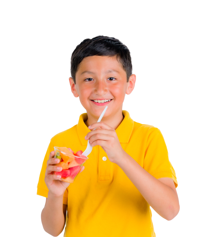 Young male wearing a yellow shirt eating fruit out of a cup.