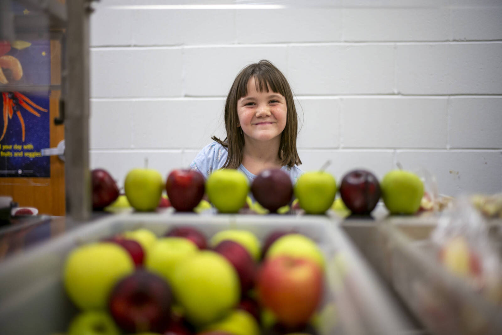 Girl smiling over apples