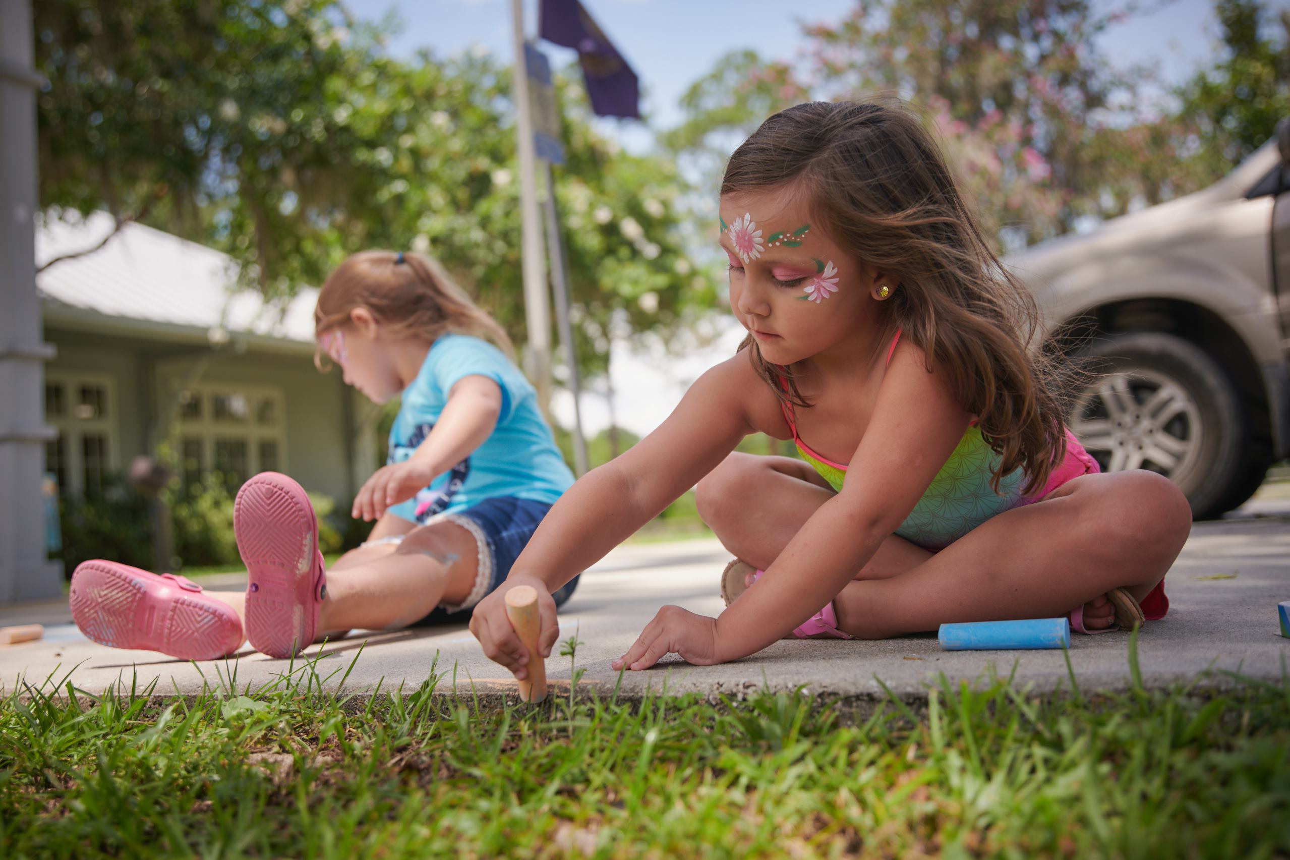 Girl sitting drawing with chalk